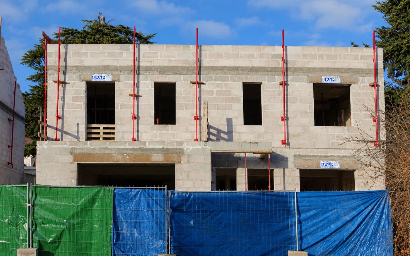 Fachada nova em blocos de concreto com juntas de argamassa e aberturas de portas e janelas